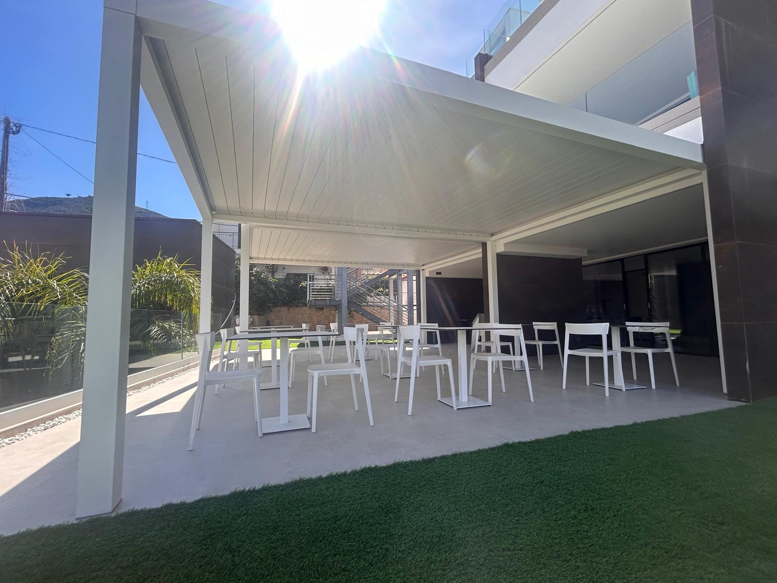 Pergola bioclimatica bianca con lame chiuse e area lounge esterna