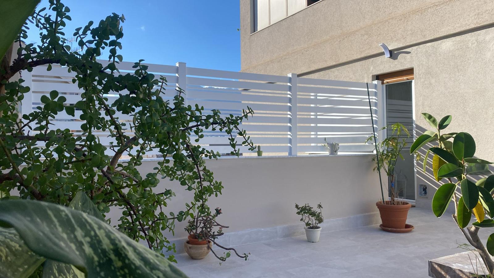 Recinzione in alluminio bianco a doghe orizzontali su terrazzo privato